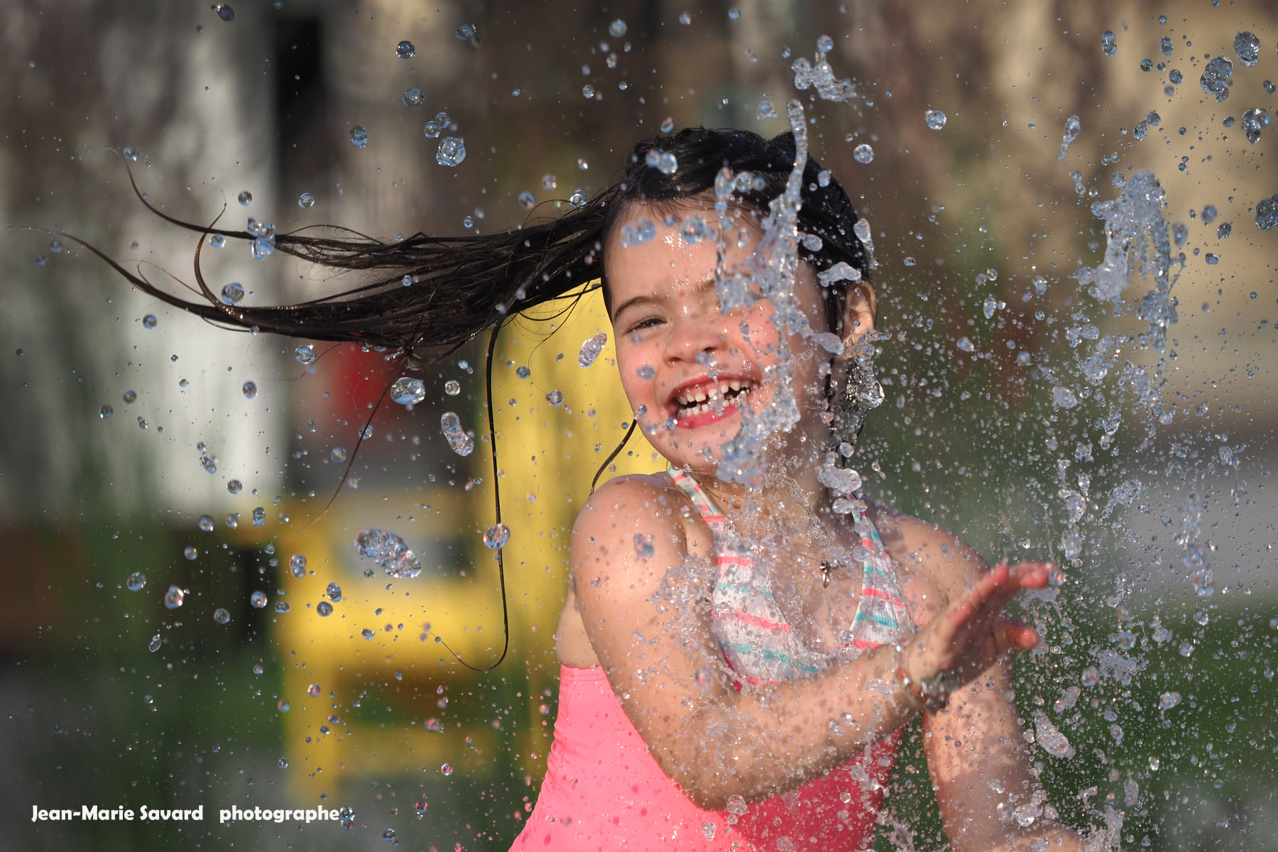 Une fillette s'amuse dans les nouveaux jets d’eau à l’Espace public de Mont-Tremblant. Photo : Jean-Marie Savard