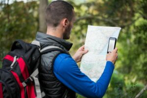 un randonneur observe une carte en randonnée