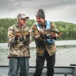 Un homme et son père à la pêche fiers de leur pêche