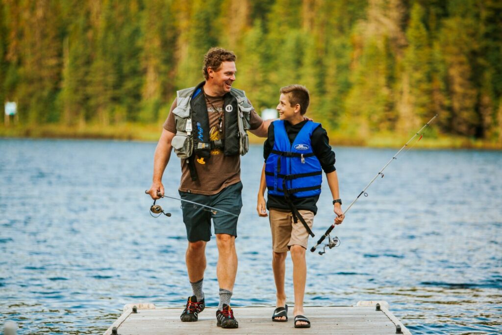 Un père et son fils avec des cannes à pêche sur un quai