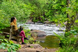 Une femme avec son chien près d'une rivière