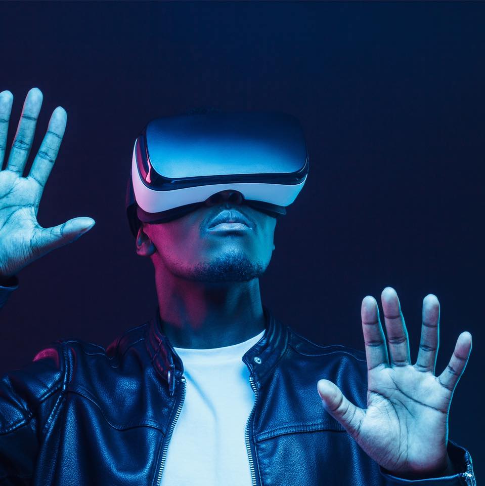 Un jeune homme ayant sur les yeux un casque de réalité virtuelle.