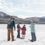 Une famille de 4 joue da la neige dans le parc régional du Mont-Tremblant