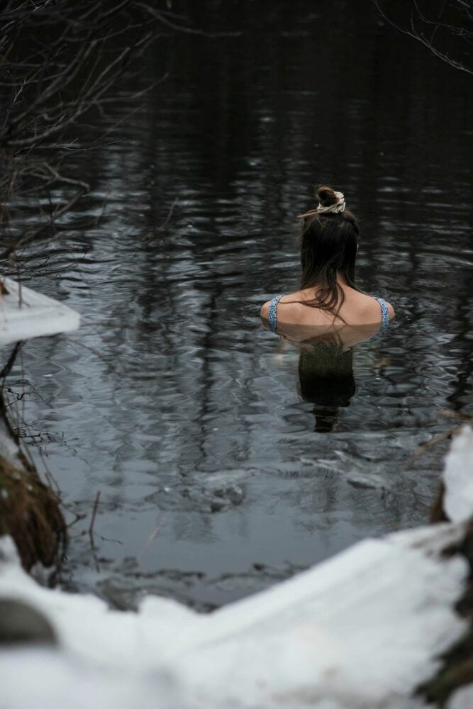 jeune femme qui fait un bain nordique dans une rivière
