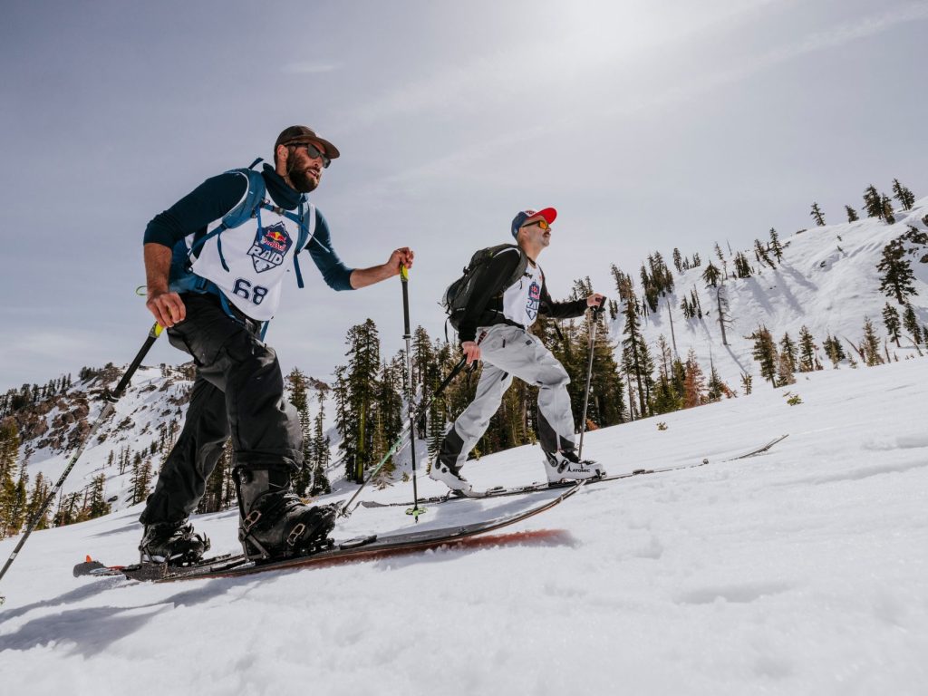 Des skieurs en rando alpine qui montent une montagne