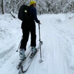 Femme en rando alpine dans un paysage hivernal des Laurentides