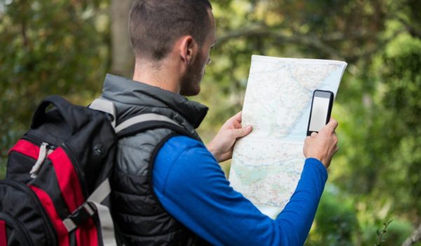 un randonneur observe une carte en randonnée